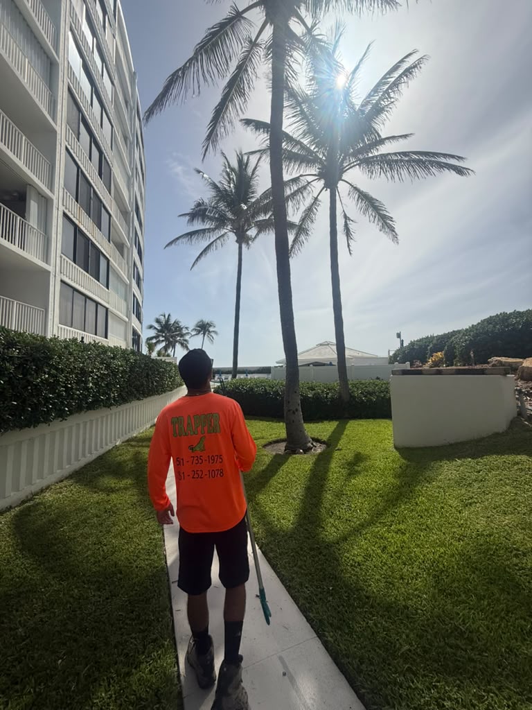 SoFlo Iguana Pros technician with a catch-pole removing an iguana at a Palm Beach County condo community